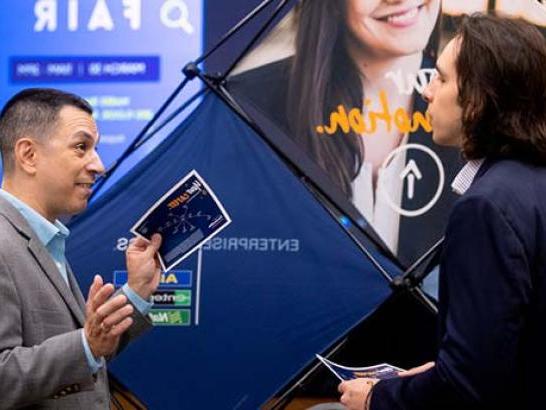 Student networks with company representative at a career fair.